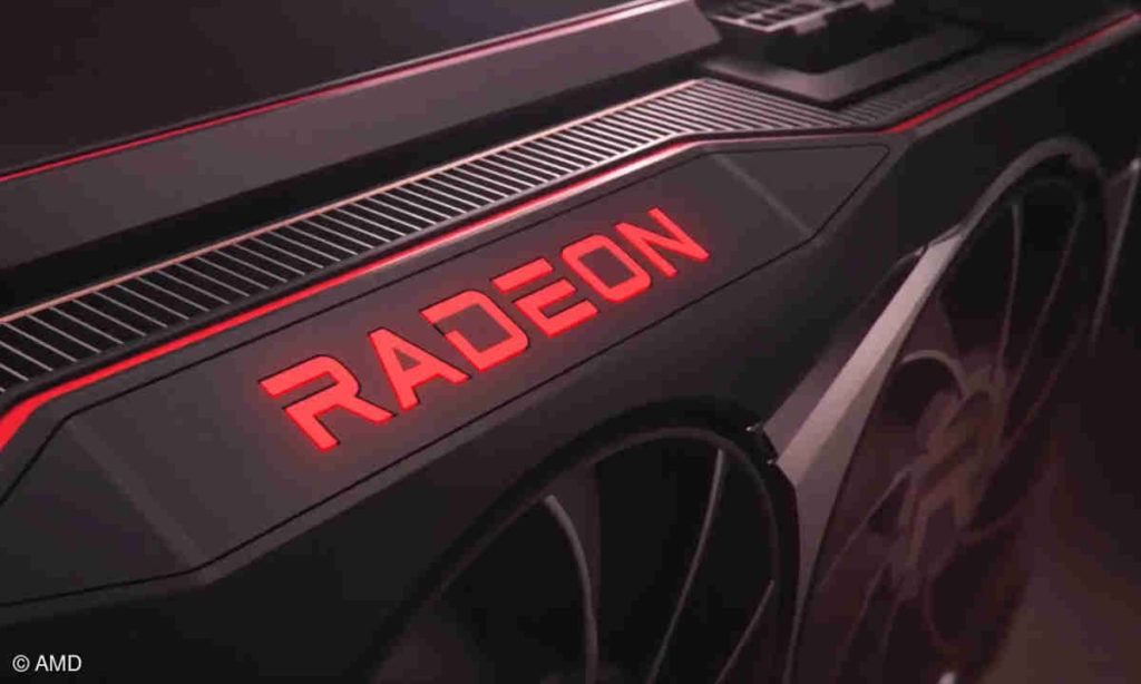 New RDNA-3 graphics cards are launched by AMD. In the picture, we see a section of a sharp red graphics card in an oblique perspective. In the center of the frame, the word "Radeon" is shown in red glowing letters in capital letters on the graphics card. Below that we see two large fans in the crop.