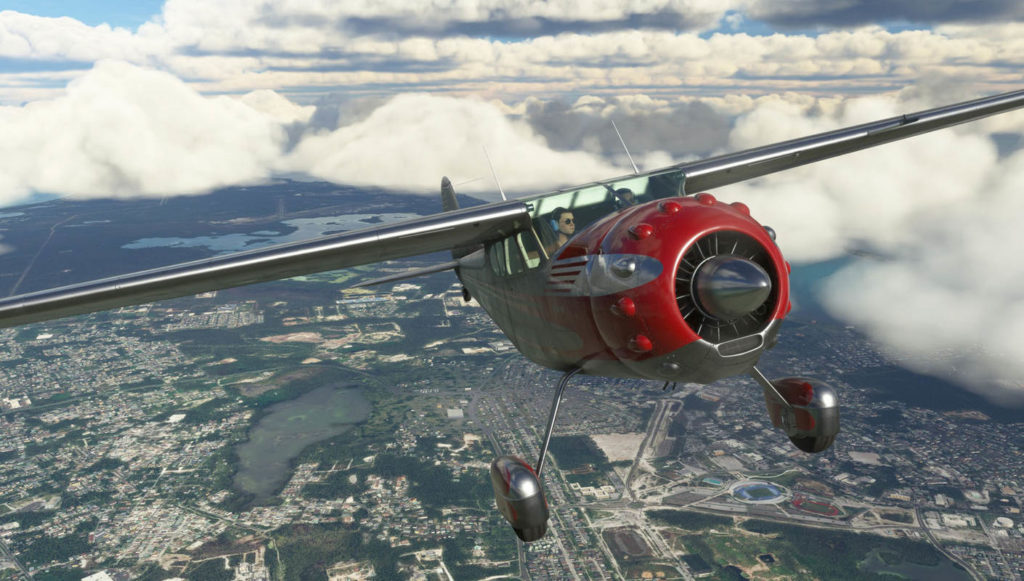 On this screenshot from the game Microsoft Flight Simulator we can see a red plane flying over a city.