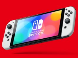 Many Nintendo rumors are circulating around the Switch 2. In this picture, we can see the Nintendo Switch (OLED model) in total view from the front in a slightly perspective view floating in front of a red background. It has white Joy-Cons here and many different colored blurred circles are shown overlaid on the reflective display. Above it is the logo with the title "Nintendo Switch" in white capital letters.