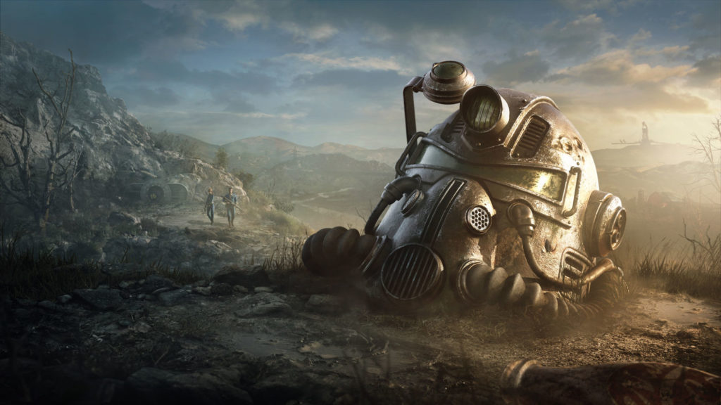 The Fallout TV show will be set in a desolate landscape, as seen here in this screenshot: On the right half of the image, a metallic gas mask full helmet from the game Fallout 76 is shown in total view. It lies on a dusty hill in the middle of a dry landscape with bare rocks. The helmet's visor reflects the setting sun, whose light hits the landscape from the right side of the image. A bit more in the background, two armed Vault boys in blue suits are depicted walking toward us on a stone path. The blue sky with many dark clouds can be seen in the background along with a mountain landscape on the horizon. A release date is still pending.