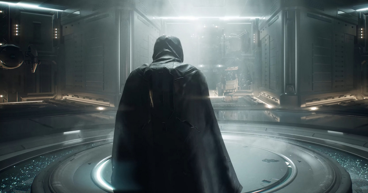 Here we see a screenshot from NCsoft's new LLL game, on which the protagonist can be seen from behind in a dark robe in third person view, as he just walks through a futuristic room, which is illuminated from above by a bright white light. In the middle of the round room, there is also a round platform, towards which the Main Character is walking. There are corridors to the right and left, and in the background of the image in front of the character, a robot-like structure can be guessed slightly. The MMORPG offers exciting gameplay and is a sci-fi shooter.