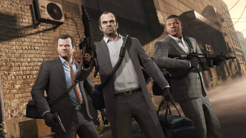 Play GTA V, one of the most popular openworld PC games. In the screenshot, we see the three main characters from the latest part of the game series in a tilted perspective in a semi-long shot. They are standing in the American shot in front of the facade of a tall, brown industrial building at dusk. They seem to be on alert, as their gazes wander past us to the left into the distance as if they've noticed something. In the center of the image, we see a man in the foreground with thinning hair, a gray suit, and a white shirt. In his right hand, he holds a submachine gun, has a bag slung around his shoulder, and is holding a bag in his left hand. The person on the left has short black hair, and is also wearing a brown suit, but has on a blue shirt and an orange and black striped tie. The person on the right is black with short black hair, has a gray plaid suit, and a white shirt. He is holding a rifle in both hands. 