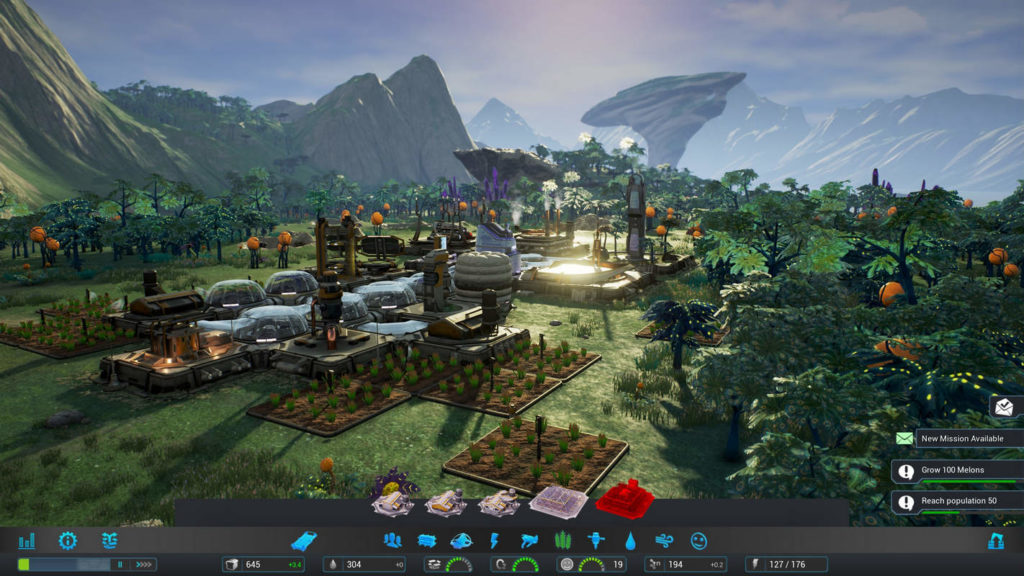 Discover and colonize an alien planet, as shown in this screenshot of Aven Colony: We see in isometric zoomed perspective an established colony on another planet in daylight. On the right and in the background green trees are shown, on which orange pumpkin-like fruits grow. In the center of the image we can see a green grassland, which extends into the foreground and background of the image. In the foreground there are several rectangular brown fields, on which green plants grow. In between, several glass domes stand side by side, extending into the background, where more different erected buildings stand. In the distance, a vast mountainous landscape can be seen in the mist and the sun is reflected in one of the glass buildings in the center of the image.