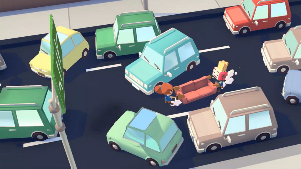 In this screenshot of Moving Out, we look down from the air at two playable characters in a long shot on a busy street in the middle of the day. The two characters, a girl dressed in blue with an orange braid and a player with a red toaster for a head, are carrying a red couch together across the street, trying to slalom past the many colorful cartoon-like cars unharmed. In the foreground on the left side, a green street sign is visible.