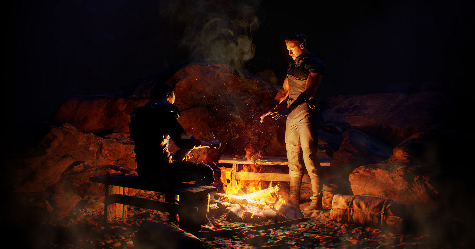 A playable teaser was released for the Gothic remake, in which gamers could already try out the gameplay and admire the graphics, as seen here in the screenshot: Two male characters dressed in medieval style are shown in the middle of the night in a long shot in front of a campfire. They are in the center of the image. The person on the left is sitting on a wooden bench and is preparing a meal with a knife. The person on the right is standing by the campfire and has both his hands stretched out over it to warm them. The fire lights up the otherwise dark place with a reddish-yellow tone. Release date of the new Gothic Game is supposed to be December 2023 for PS5.