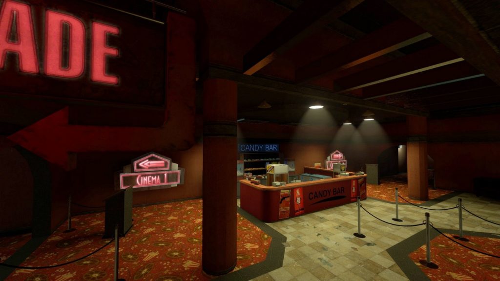 From an elevated position, we look at a rectangular u-shaped red bar counter with the inscription "Candy Bar" in black capital letters. The counter is a bit more in the background relatively in the center of the image and is located in a large hall with a dark red ceiling and orange-red walls. Two columns are standing in the room. The floor is made of brown-colored tiles, on which there are three red carpets with patterns on the left, right, and in front of the bar counter. Three white ceiling lights illuminate the counter, otherwise, the room is quite dark to the sides. In front of the left side of the picture we see a red arrow pointing out of the picture to the left and below it, in the background, a neon sign is shown that reads "Cinema" in bright red capital letters. This is a cutout of a playable map from the game, which is available for free.