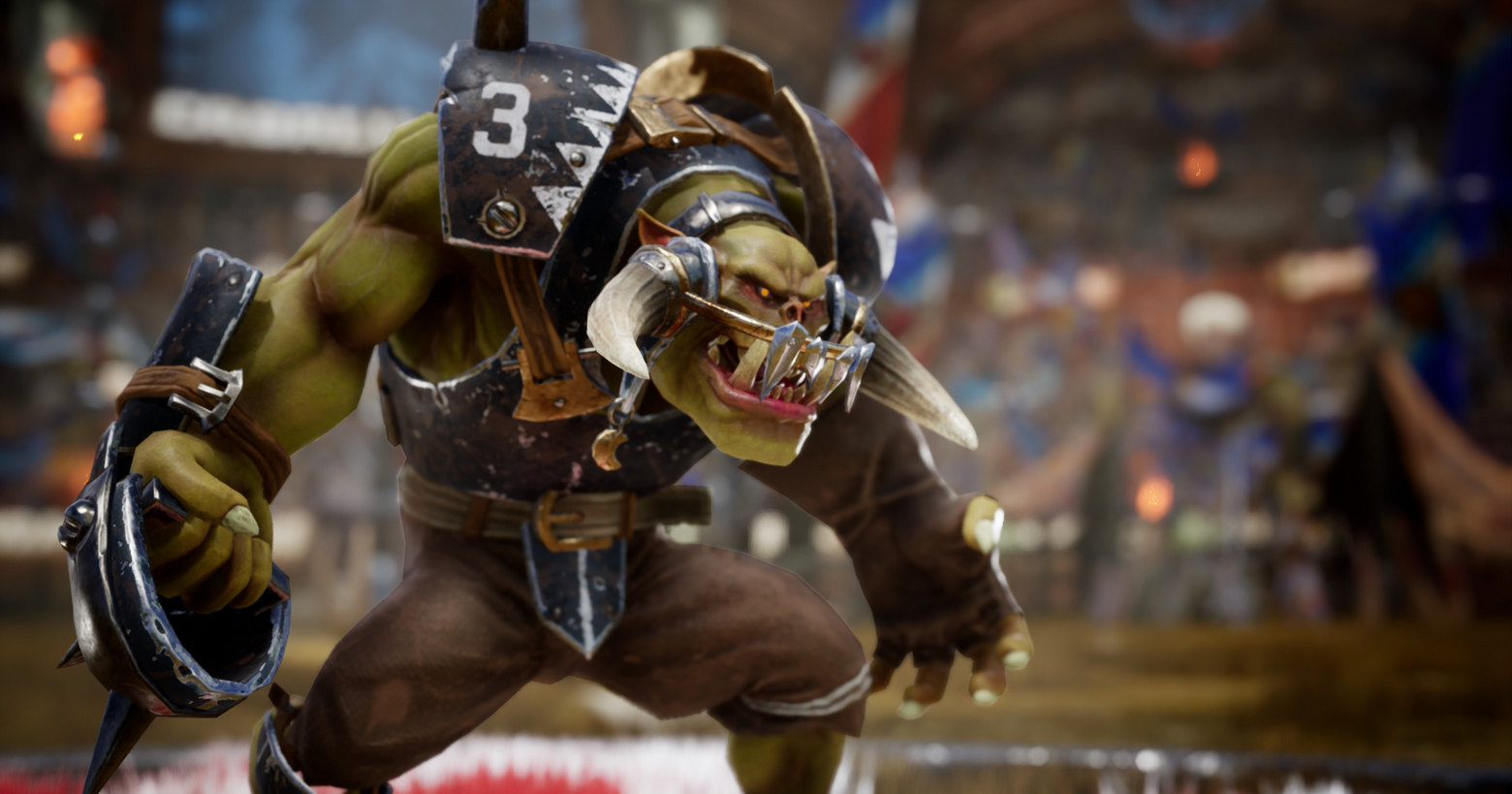 We can see an Orc from Blood Bowl 3 in this screenshot. He is shown in the semi-close-up in the half-profile on the left of the image. The muscular, green-skinned creature wears brown cloth pants and has football-like iron armor. In front of his mouth, the orc wears a kind of protection in the form of a brace. In his right hand, he holds a football brown-leather ball device. With a pouty mouth and sharp teeth, he looks to the right. In the background, the tribune is shown with blue banners in a solid blur. The scene takes place during the day. A release date is confirmed for February, and there will likely be crossplay.