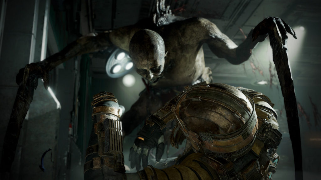 In this screenshot, we look over the shoulder of a soldier in a metallic battle suit and metal helmet. He has just been knocked to the ground by a so-called Necromorph and we see the soldier in a semi-close-up in the lower half of the picture. Our gaze falls here on the very pale-looking human-like monster, which, however, has two huge blades sticking out of its hands. With its mouth wide open, it lunges over its victim, ready to kill him. The scene takes place in a dark corridor in the spaceship. The room is lit only by two white spotlights, giving the scene an arid atmosphere.