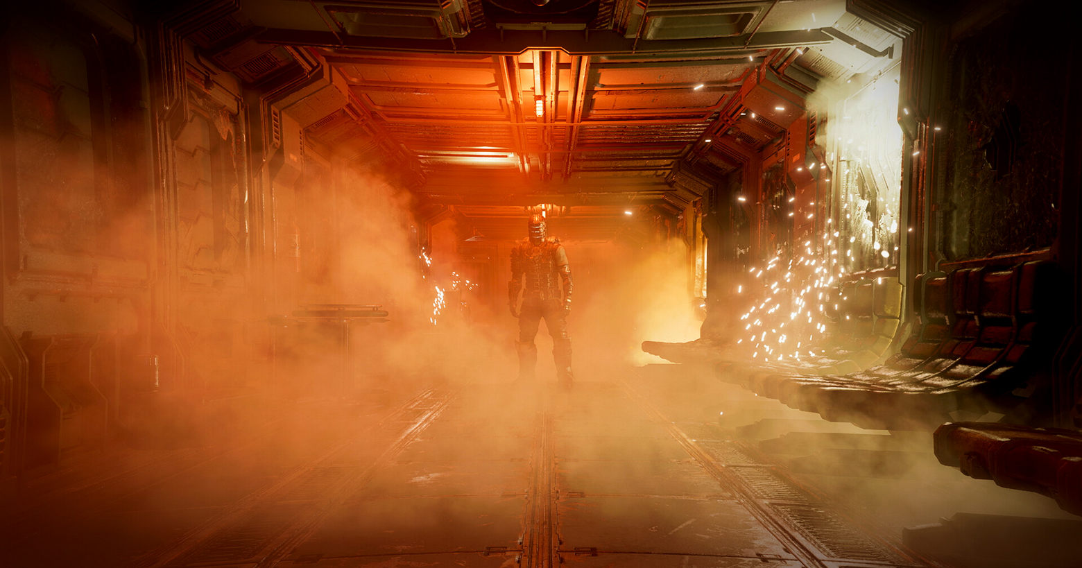 This screenshot shows a scene from the Dead Space Remake. We are on board a spaceship and are standing in the middle of a long corridor, which just runs into the background and is illuminated by an orange ceiling light. A lot of smoke is in this corridor. On the right side of the wall is an electrical device, which seems to be defective and from which a lot of sparks and smoke are coming out. At the end of the corridor, we catch a glimpse of the protagonist, Isaac Clarke, in a long shot, standing directly facing us. He has a dark combat suit and a very futuristic-looking helmet that consists of three glowing horizontal lines running parallel around the helmet. The game's release date is set and it will also be available for EA Play for free.