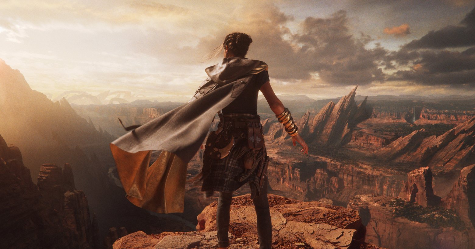 The protagonist Frey Holland can be seen here in a long shot from behind in the center of the picture. She stands on a reddish-brown rocky outcrop directly in front of a huge canyon and looks into the distance on the left. In the background, many other similar rocks and canyons can be seen and the evening sun bathes the scenery in an impressive mood. The sky and the clouds get a warm tone from the evening sun. Forspoken now has a clear release date and will first appear for PC and PS5. In 2025 it will most likely be released for Xbox and other consoles.