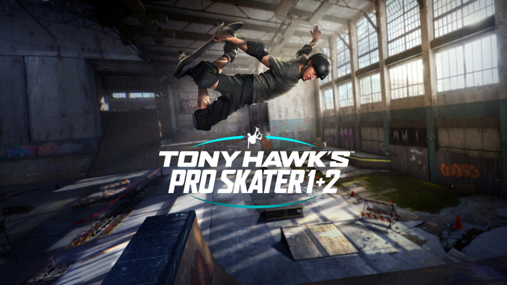 We are in a skateboarding park in the middle of a large industrial hall. On the right side of the picture, there is a huge window front through which the daylight shines in and illuminates the hall impressively. At the bottom of the image, many different ramps are shown. In the center, the game's logo is shown in white capital letters “Tony Hawk's Pro Skater 1+2” along with two turquoise curved lines framing the logo above and below. Above it, we see the skateboarder Tony Hawk in a brown t-shirt, black pants, and black skateboard helmet performing an impressive stunt just in the air.