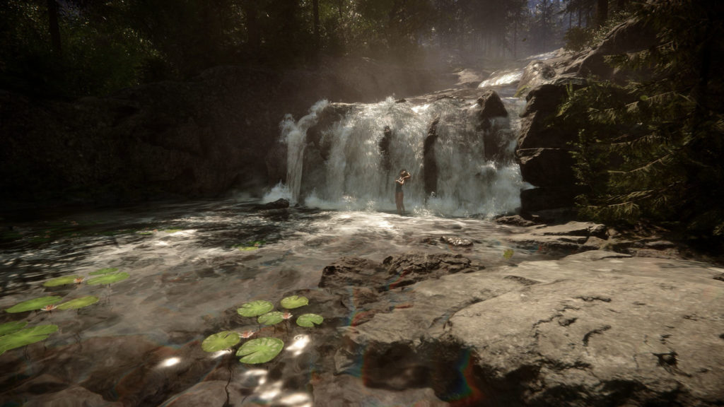 As the player, we are looking at an extremely realistic-looking waterfall in the middle of an equally realistic-looking forest. The waterfall is seen in the upper right in a long shot and the water flows from the upper right out of the background down to the lower left in the foreground of the image. A lot of sprays are represented on the water. In the lower left of the image, several water lilies can be seen on the surface of the water. At the bottom right of the picture, there is a rock leading to the water. At the top left of the image, we can see numerous trees on a rocky outcrop. The scenery is impressively illuminated by many rays of sunlight and directly in the center of the waterfall stands a woman in a green swimsuit.