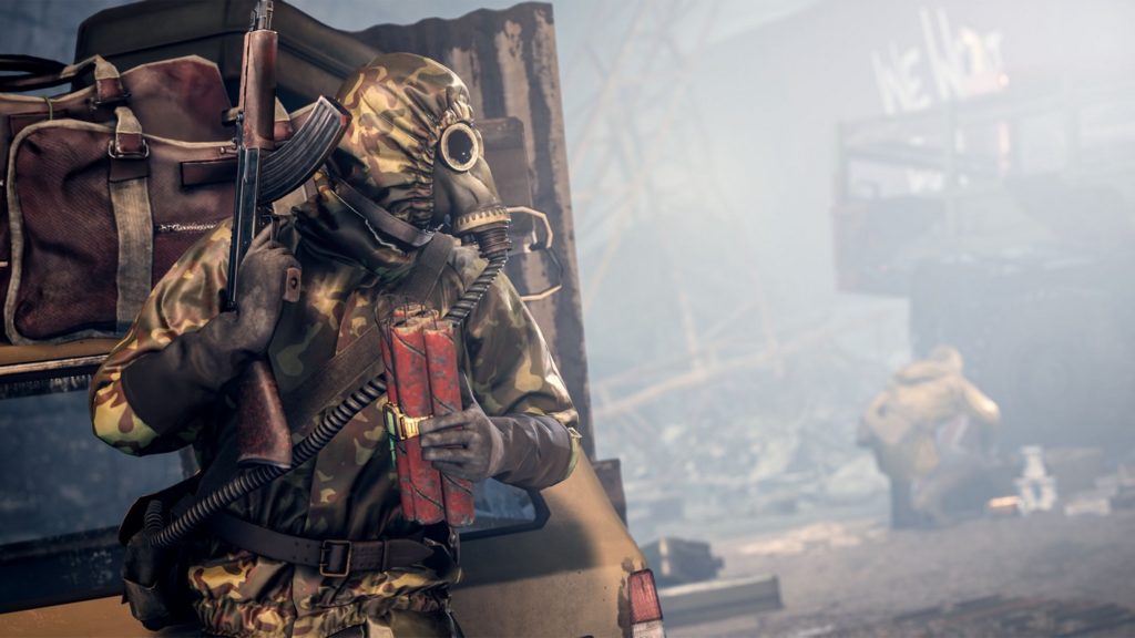 Exciting combat and the sheer fight for survival make Vigor one of the best survival games for PS4 and PS5, as illustrated in this screenshot: The player can be seen in the left foreground in the semi-close-up. He is wearing a yellow-brown colored camouflage combat suit and a gasmask over which he has pulled his hood. In his right hand, he holds a Kalashnikov upwards and has a homemade dynamite bomb in his hand. He leans hidden against a brown car and has spotted an enemy player, whom we see in the background on the right of the picture, blurred in the long shot, as he kneels in front of something. This player is wearing a yellow jacket and beige pants. The players are in a destroyed urban environment in the middle of the day and there is a lot of fog in the air.