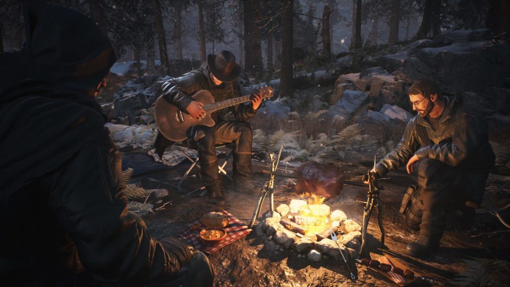 Three survivors can be seen sitting around a campfire in this screenshot. The camp is in the middle of a snowy forest at night. On the left in the crop, one of the characters with a leather jacket and hood over his head can be seen in profile. In the center of the image, in a long shot, we see a character playing guitar and wearing a cowboy hat. On the right sits a character with a similar leather jacket, black hair, and a beard. He wears glasses and is leaning over the campfire to look at the goose that the three men are roasting over the fire. It is snowing and the scene is idyllically illuminated by fire.