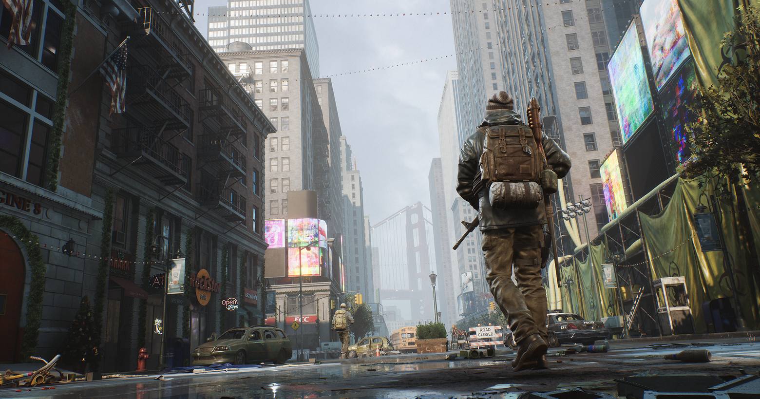 In this screenshot of the survival MMO The Day Before, we see two soldiers from behind from the bottom view, as they walk on a street through a deserted city. We are in the middle of the street, which just runs straight into the background. One armed soldier is already very far in the background and can be seen at the bottom center of the image. The other soldier has just passed us on the right and we catch sight of him in the wide shot on the right half of the picture. On the street are several destroyed cars and the devastation is very well represented in the picture. On the right and left sides are high building facades to see and in the background, we also see high skyscrapers in the fog. At the end of the street at the bottom center of the picture, there is a large bridge behind the buildings. The game will offer impressive co-op and PvP gameplay and supports cross-platform and maybe crossplay.