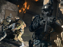An armed soldier in a black uniform from Warzone Season 2 walks in our direction, while in the background two soldiers are in close combat.