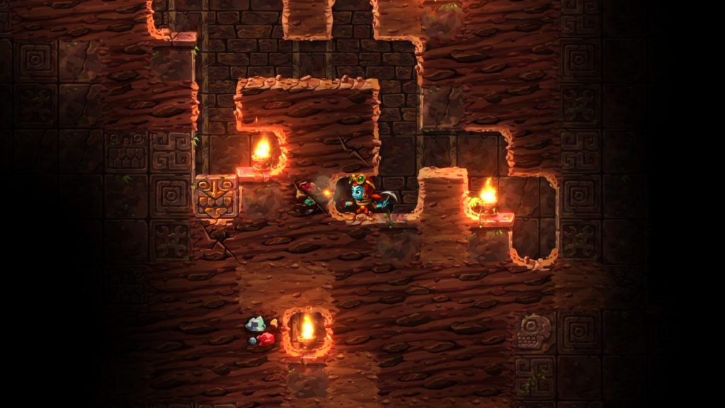 In this screenshot from Steamworld Dig 2, we see the player in a long shot in the center of the image, digging through the 2D underworld. The character has a blue hat, a big cute head, and a cave explorer outfit with raised goggles. In his left hand, he holds a pickaxe, with which he has already dug down several branching rectangular tunnels from above. To the left and right, he has placed two lighted torches on the ground to illuminate the scene. At the bottom center of the image, an existing hole in the ground can be seen with another lighted torch in it. Directly to the left of it are two blue gems, one red gem, and one yellow gem in the ground. Also to the player's left are three different colored gems, which he is about to dig up. With Steamworld Dig 2 you play one of the best Metroidvania games with a feel-good factor.