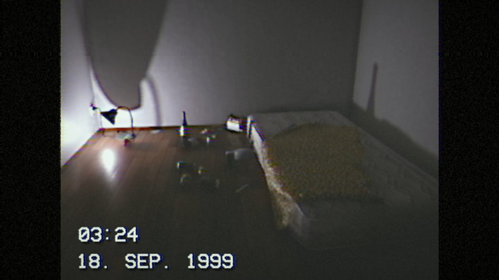 From a first-person perspective, we stand in a small square quite empty room with white walls and a brown parquet floor. In the back left corner, there is a small nightstand lamp on the floor that is turned towards the wall and illuminates the room somewhat. The light casts an ominous high shadow on the back wall emanating from the lamp. On the right, a dirty white bed mattress can be seen, on which lies a small blanket with a leopard print. To the left are several empty alcohol cans and wine bottles and an ashtray with many cigarette butts. At the bottom left of the picture, the time of the recorded videotape can be read in white letters "03:24" Below that, we read the date “Sep. 18, 1999” in capital letters. The game is created in found footage style and looks like a VHS tape recording, which looks frighteningly real and authentic.