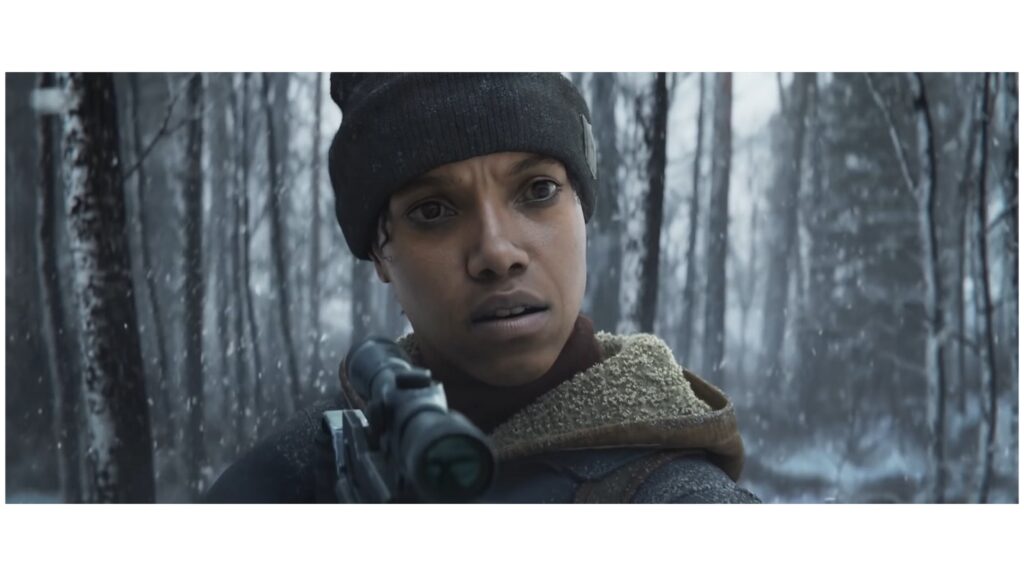 We see the State of Decay 3 protagonist in a snowy forest in a close-up. She holds a crossbow in her hands.
