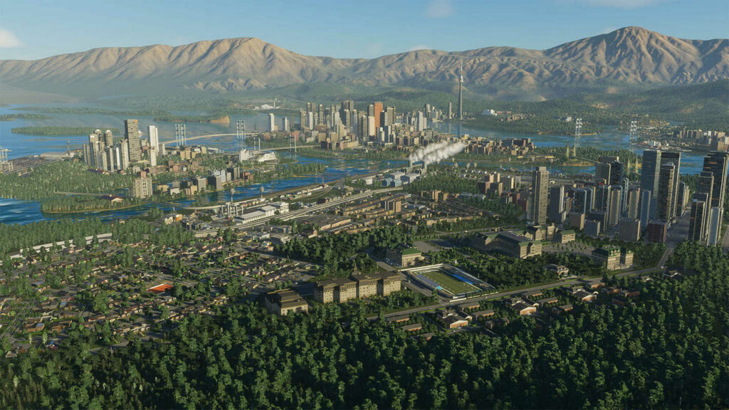 A complex city with various skyscrapers and streets is shown in a long shot. In the background, we see mountains.